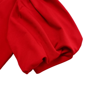 Detail of red puffed sleeve cuff showing elastic knit fabric and fine texture stitching