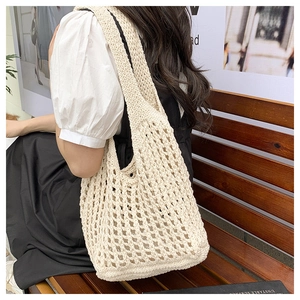 Detail of hand-woven hollow mesh texture on a cream white crochet tote bag