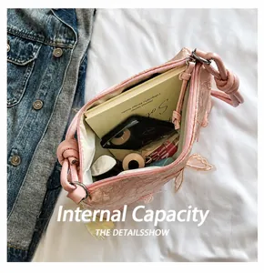 Detail of pink lace shoulder bag interior showing capacity for cosmetics and a notebook