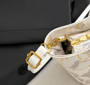 Detail of floral tote bag showing golden hardware zipper and adjustable leather strap