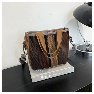 Detalle del gran bolso tote tejido a rayas con correa gris desmontable y cierre metálico