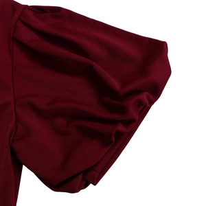 Detail of burgundy puff sleeves showing pleated knit fabric texture and craftsmanship