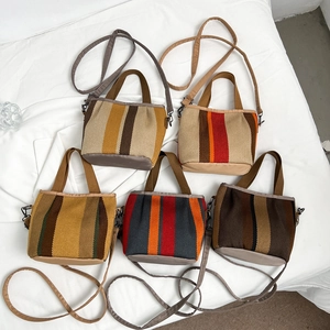 Cinco bolsos tote tejidos a rayas de colores con correas ajustables sobre tela blanca