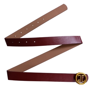 Close-up of wine red leather belt with round gold buckle and polished finish