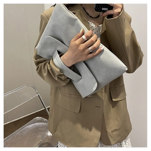 Nahaufnahme der hellblauen Handtasche aus Kieselleder mit minimalistischem Griff für Damen