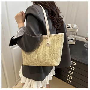 Détail d'un sac cabas en paille tissée avec motif à chevrons et anses en cuir véritable