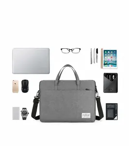 Deep gray waterproof canvas laptop bag shown with organized tech accessories for storage
