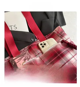 Detail of red and white checkered tote bag with nylon handle and outer pocket