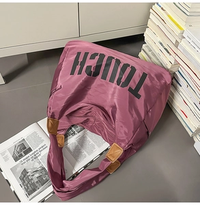 Dettaglio della borsa tote viola in nylon con stampa TOUCH e rinforzi in pelle sintetica