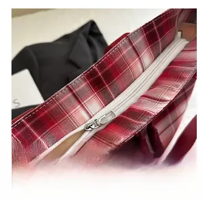 Detail view of smooth white zipper closure on red and white checkered canvas tote bag