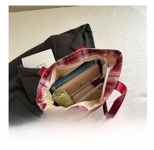 Internal view of red plaid canvas tote bag showing large capacity for daily essentials