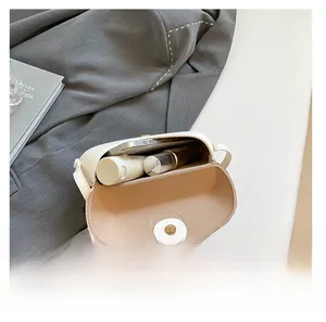 Internal view of a white vintage saddle bag showing space for phone and makeup