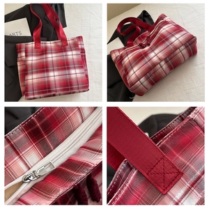Detail view of red plaid tote bag showing stitching, zipper close-up and durable fabric