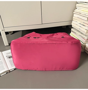 Dettaglio della struttura del fondo largo e del tessuto in nylon impermeabile della borsa rosa