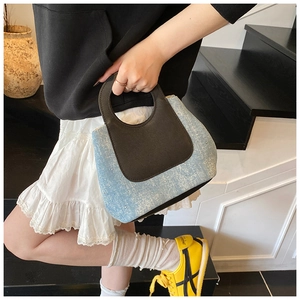 Detailopname van denim emmertas met leren handvatten en contraststiksels