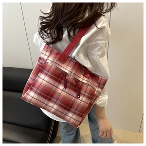 Détail du grand sac cabas à carreaux rouge et blanc porté par un mannequin pour l'école