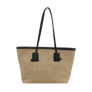 Sac cabas en paille avec lanières en cuir noir et nœuds décoratifs sur fond blanc