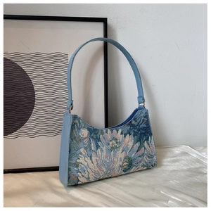 Detail of floral jacquard underarm bag with light blue PU leather trim on white silk