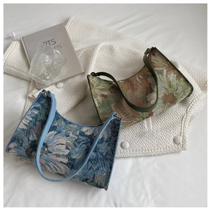 Detail view of floral jacquard hobo bags in blue and brown with leather straps