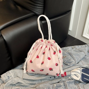 Rosa Cordbeutel mit Erdbeermuster und weißen Kordelgriffen auf Denim-Hintergrund