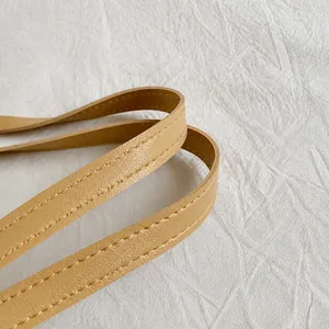Close-up of light brown synthetic leather handle with detailed stitching on tote bag