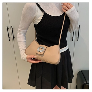 Détail du sac à bandoulière beige avec une boucle carrée en cristal argenté brillant