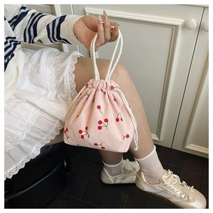 Detailaufnahme der rosa Cord-Beuteltasche mit süßen Kirsch-Stickereien und Kordelzug