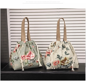 Détail de sacs seaux à fleurs en coton et lin avec cordon de serrage en gris et crème