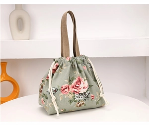 Détail du sac seau en tissu imprimé floral avec cordon de serrage et anse tressée