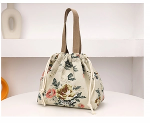 Détail du sac seau en toile imprimé floral avec fermeture par cordon et poignées marron