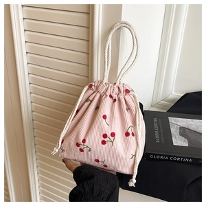 Detailansicht der rosa Cord-Handtasche mit Kirschprint und weißem Baumwollkordelzug