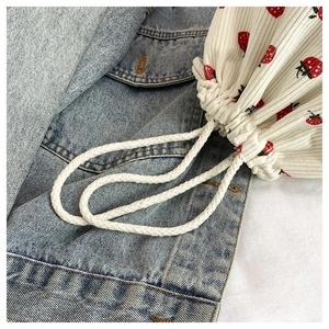 Nahaufnahme der Cord-Beuteltasche mit Erdbeerdruck auf einem Hintergrund aus Jeansstoff