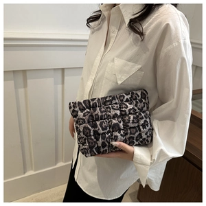 Quilted leopard print makeup bag held by a model for a stylish lifestyle detail view