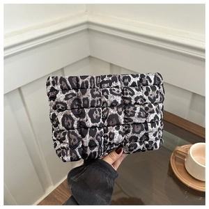 Close-up of leopard print quilted toiletry bag with textured hand-held lifestyle detail