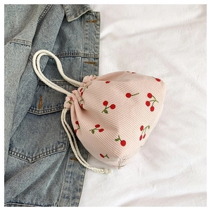 Detail der rosa Cord-Beuteltasche mit Kirschstickerei und weißen Baumwollseil-Griffen
