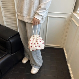 Detailaufnahme der Cordtasche mit Erdbeermuster, Kordelzug und gewebtem Griff
