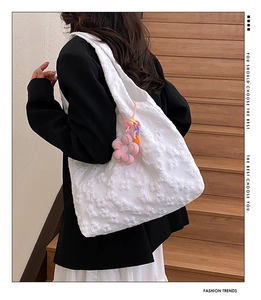 Detail of 3D butterfly embroidery on white tote bag with pink flower charm pendant