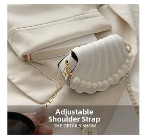 Detail of adjustable gold chain strap on the white pearl shell bag for women
