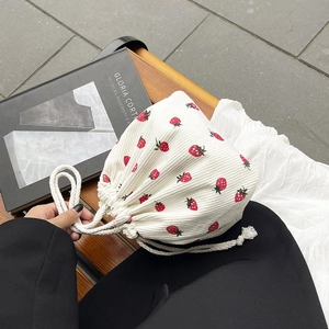 Detail einer weißen Cord-Beuteltasche mit roten Erdbeeren und Kordelzugverschluss