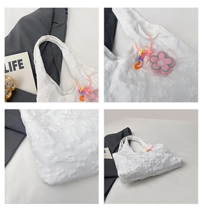 Detailed macro view of white 3D floral texture fabric and colorful flower bag charm