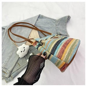 Detail of multi-color woven tote bag with leather straps and cloud plush charm