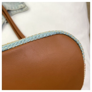 Detail of the woven edge and brown faux leather bottom on this commuting tote bag