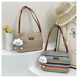 Detail of woven tote bag with leather strap, zipper closure and cute plush charm
