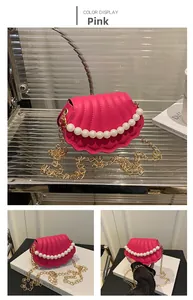 Detail of pink shell-shaped mini bag featuring pearl decoration and gold chain strap
