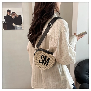 Détail du sac bandoulière tissé en forme de cœur avec initiales SM et bordure noire