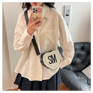 Sac à bandoulière tressé en forme de cœur avec lettre porté par le mannequin