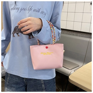 Pink handbag with beaded handle and Fantasy Romance print shown in a lifestyle setting