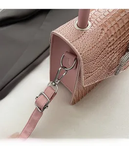 Close-up of pink faux crocodile skin texture with silver hook and rhinestone snake charm