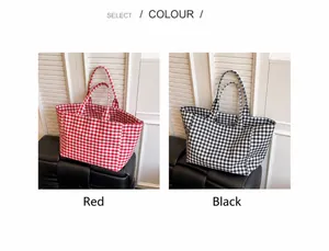 Detail view of large canvas tote bags in red and black gingham patterns for shopping