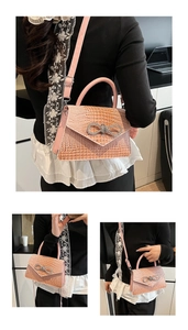 Detail of pink crocodile texture handbag with sparkling rhinestone bow and shoulder strap